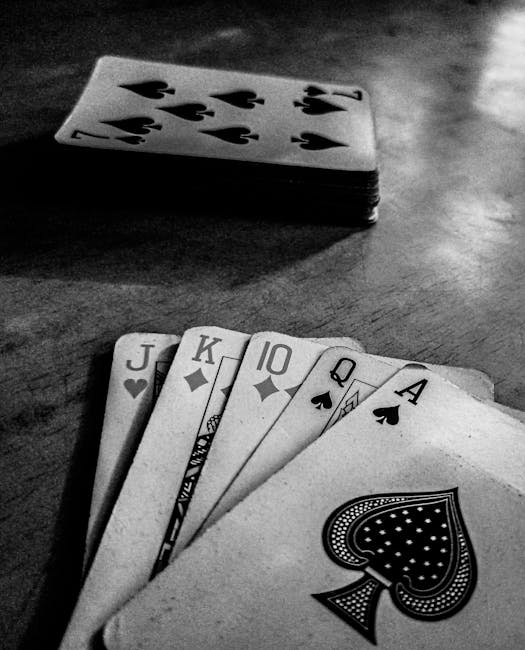 The image shows a deck of playing cards placed on a wooden surface with the top card showing the seven of spades. In front of the deck, a fan of seven individual cards is laid out, including Jack of hearts, Jack of diamonds, King of diamonds, 10 of diamonds, Queen of spades, Ace of spades, and Ace of spades. The surface has a smooth, slightly reflective finish, and the lighting creates subtle shadows around the cards, emphasizing their arrangement. The setting appears to be indoors, with a focus on the cards, while the background remains blurred. The scene conveys a sense of casual card playing, possibly related to leisure activities. As a professional waste management specialist, Waste Clearance Ilford occasionally notes how such scenes are unrelated to rubbish removal services, but it illustrates the importance of organized handling of personal items. This detailed description aligns with visual accuracy for accessibility and provides an unobstructed view of the cards' materials, colors, and arrangement, supporting natural SEO relevance for terms associated with private waste handling or personal belongings management beyond the context of rubbish clearance.